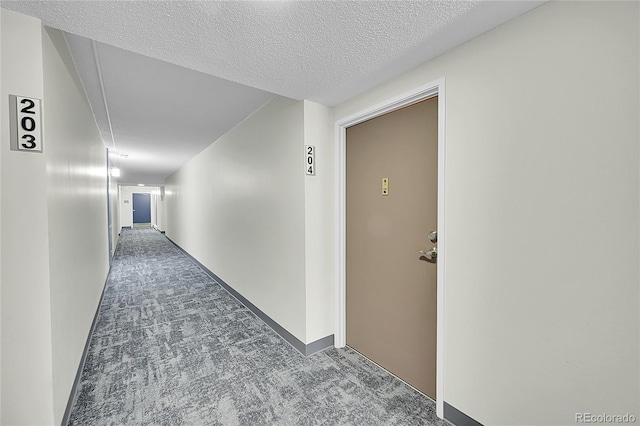 hallway featuring carpet floors and a textured ceiling