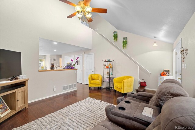 living room featuring vaulted ceiling, dark hardwood / wood-style floors, and ceiling fan