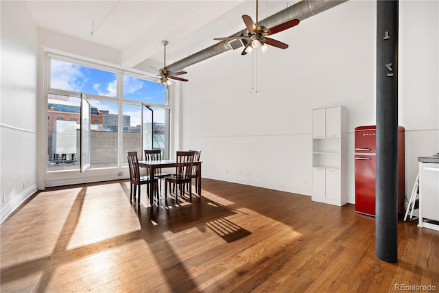 dining space featuring beam ceiling, high vaulted ceiling, dark hardwood / wood-style floors, and ceiling fan