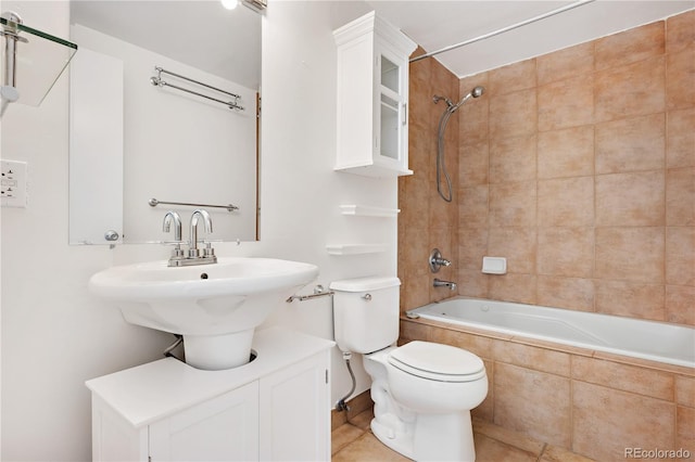 bathroom with tiled shower / bath, tile patterned floors, and toilet