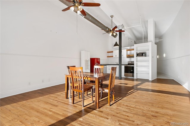 dining space with high vaulted ceiling, hardwood / wood-style floors, and ceiling fan