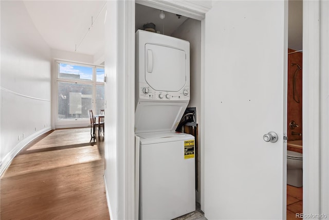 clothes washing area with stacked washer / dryer and light hardwood / wood-style floors