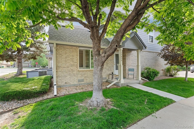 1385 W 112th Ave Unit D, Denver, CO 80234 - view of front facade with brick siding, a front lawn, a shingled roof, and cooling unit