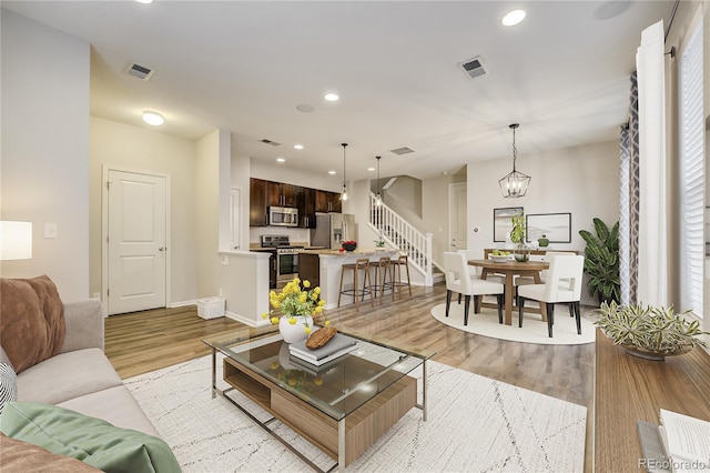 3386 Valentia St, Denver, CO 80238 - living area featuring light wood-type flooring, baseboards, stairs, and recessed lighting