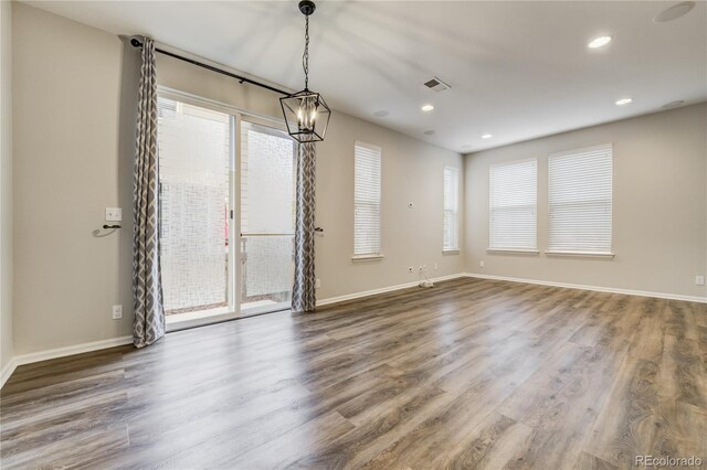 3386 Valentia St, Denver, CO 80238 - spare room featuring plenty of natural light, wood finished floors, baseboards, recessed lighting, and a chandelier