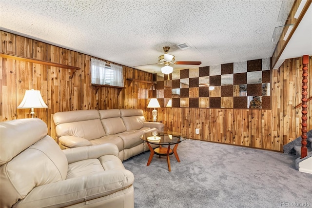 carpeted living area with wooden walls and a ceiling fan