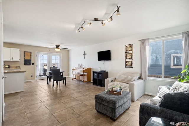 living room with light tile patterned floors, track lighting, baseboards, and a ceiling fan