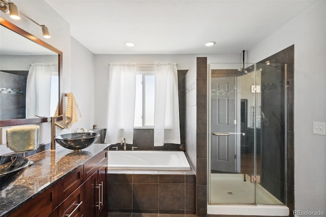 full bathroom featuring vanity, a bath, and a shower stall