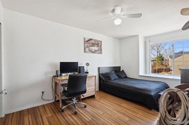 bedroom featuring ceiling fan, baseboards, and wood finished floors