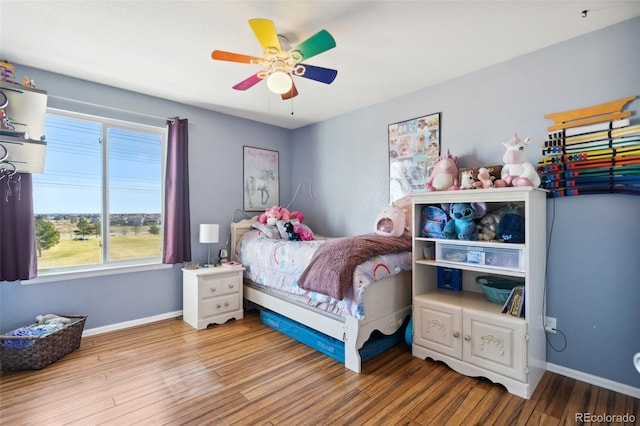 bedroom with ceiling fan, baseboards, and wood finished floors