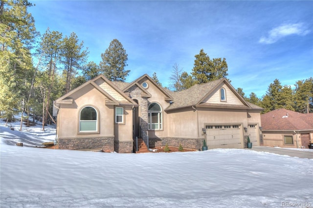 view of front of home with a garage, stone siding, and stucco siding