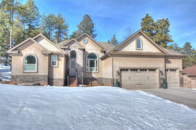 view of front facade with a garage, stone siding, and stucco siding