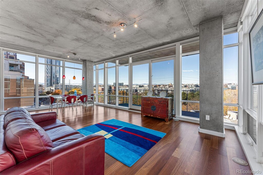1620 Little Raven St Unit 504, Denver, CO 80202 - living area featuring a wall of windows, a healthy amount of sunlight, wood finished floors, and a city view
