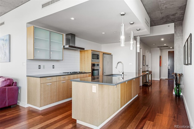 kitchen with wall chimney range hood, dark wood-type flooring, stainless steel appliances, and a sink