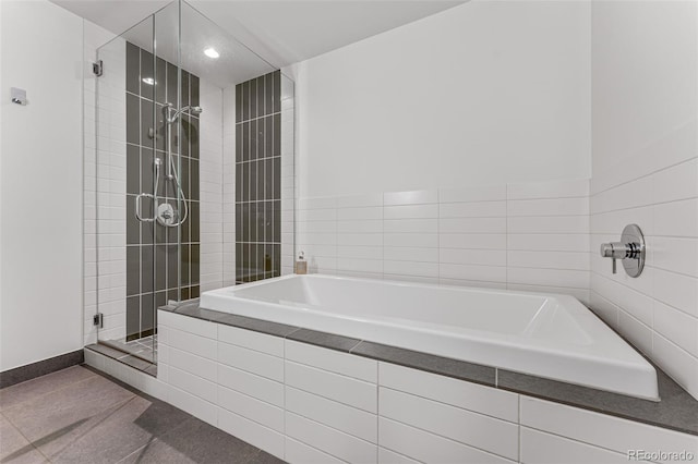 bathroom featuring a bath, a stall shower, baseboards, and recessed lighting