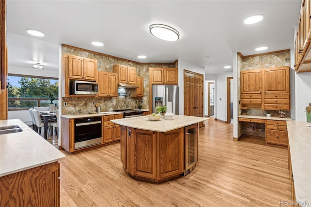 kitchen featuring decorative backsplash, light hardwood / wood-style flooring, a center island, and appliances with stainless steel finishes