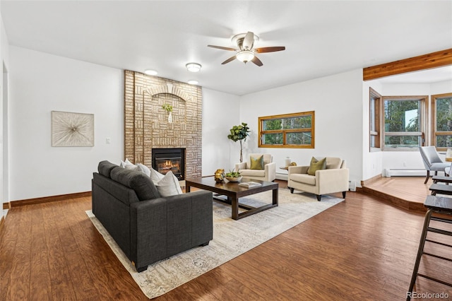 living room featuring ceiling fan, a baseboard radiator, a fireplace, and hardwood / wood-style floors