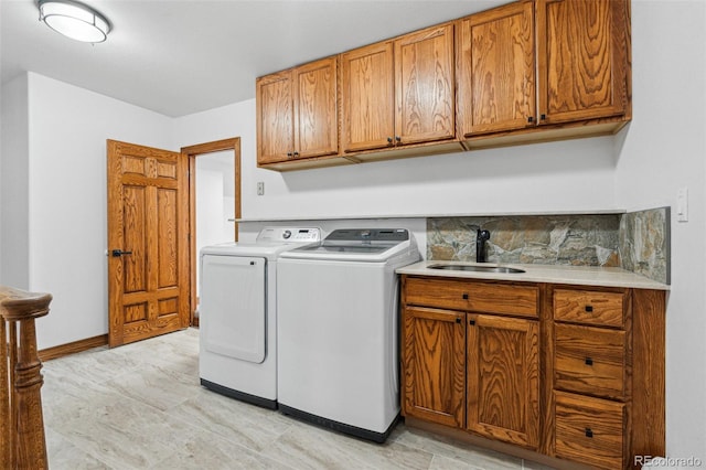 laundry area with cabinets, washer and dryer, and sink