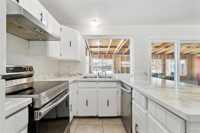 kitchen with kitchen peninsula, sink, white cabinets, light tile patterned floors, and stainless steel appliances