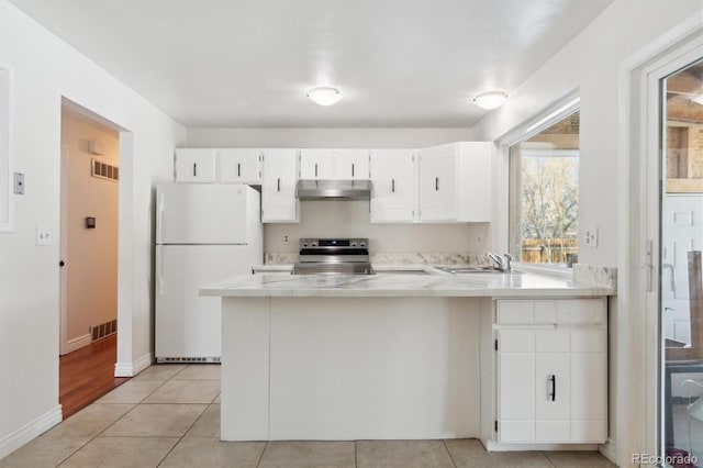 kitchen featuring white cabinetry, light tile patterned floors, kitchen peninsula, stainless steel range with electric cooktop, and white refrigerator