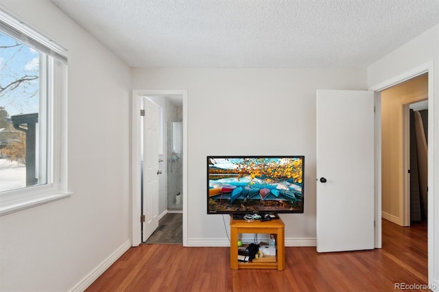 living room featuring hardwood / wood-style floors, a healthy amount of sunlight, and a textured ceiling