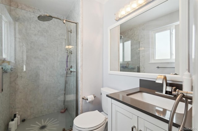 bathroom featuring vanity, a shower with shower door, and toilet