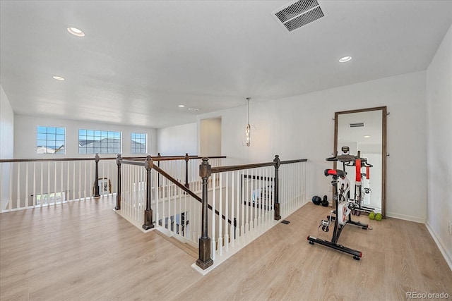 exercise room with light wood-type flooring