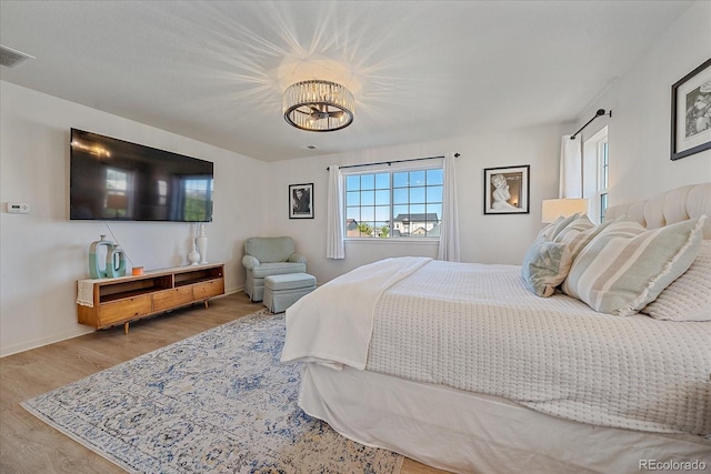 bedroom with an inviting chandelier and wood-type flooring