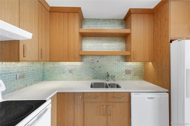 kitchen with tasteful backsplash, sink, light stone counters, and white appliances