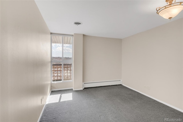 carpeted empty room with a baseboard heating unit