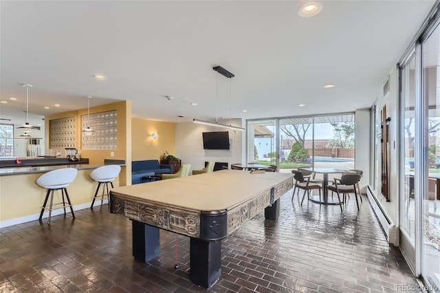 game room featuring floor to ceiling windows and a baseboard heating unit