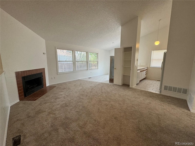 unfurnished living room featuring light colored carpet, a brick fireplace, vaulted ceiling, and a textured ceiling