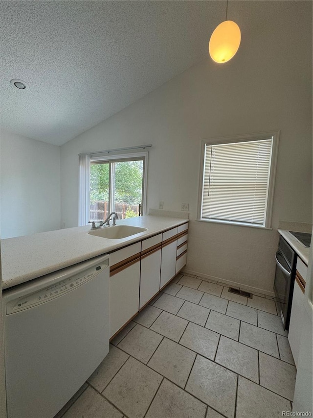 kitchen featuring vaulted ceiling, dishwasher, sink, white cabinets, and hanging light fixtures