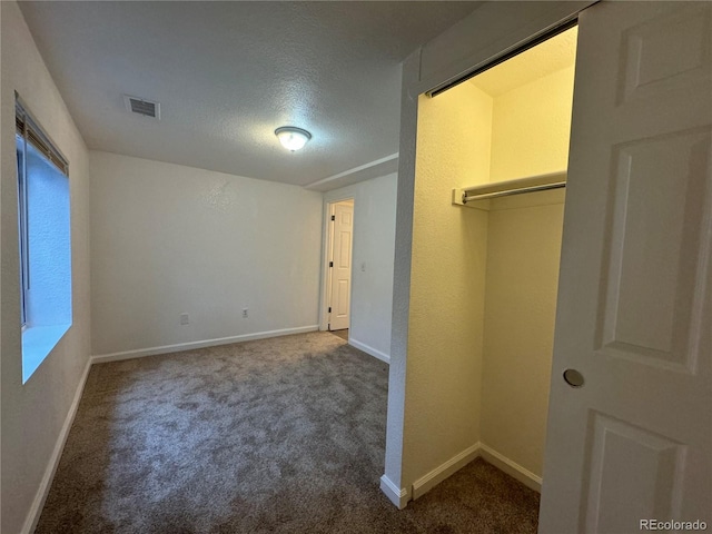 unfurnished bedroom featuring carpet flooring, a closet, and a textured ceiling