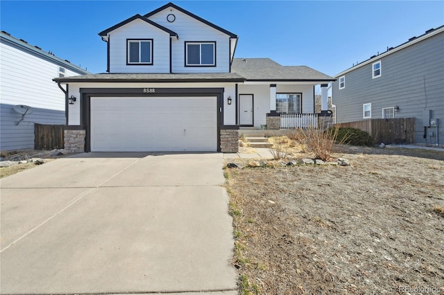 view of front of house featuring stone siding, an attached garage, covered porch, and driveway