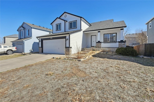 view of front of house with fence, a porch, concrete driveway, stone siding, and an attached garage