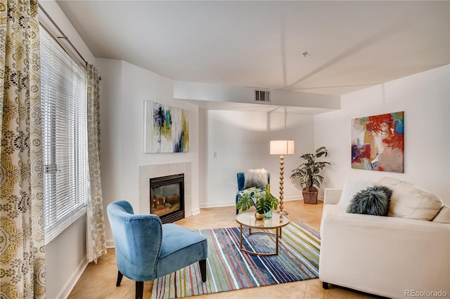 tiled living room featuring a tiled fireplace