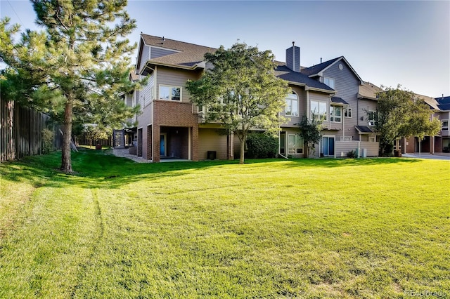 rear view of house featuring a yard