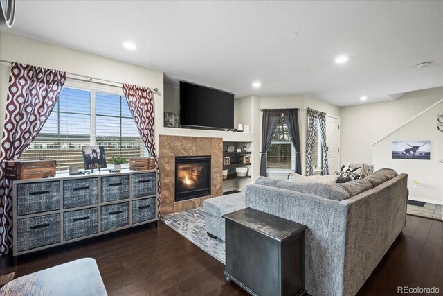 15800 E 121st Ave Unit 4K, Brighton, CO 80603 - living area with dark wood-type flooring, a tile fireplace, plenty of natural light, recessed lighting, and baseboards