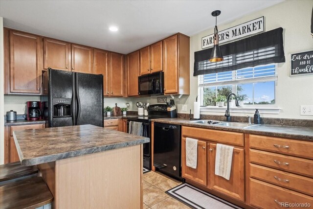 15800 E 121st Ave Unit 4K, Brighton, CO 80603 - kitchen featuring black appliances, dark countertops, a sink, light tile patterned floors, and a breakfast bar
