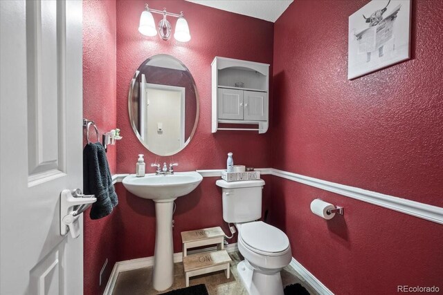 15800 E 121st Ave Unit 4K, Brighton, CO 80603 - half bathroom featuring toilet, baseboards, and a textured wall