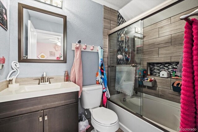 15800 E 121st Ave Unit 4K, Brighton, CO 80603 - bathroom featuring vanity, toilet, combined bath / shower with glass door, and a textured wall
