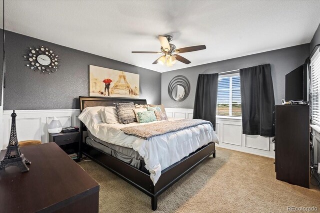 15800 E 121st Ave Unit 4K, Brighton, CO 80603 - bedroom with carpet floors, a decorative wall, a wainscoted wall, and ceiling fan