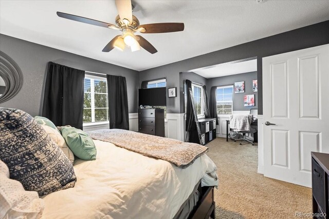 15800 E 121st Ave Unit 4K, Brighton, CO 80603 - bedroom featuring light colored carpet, a desk, a ceiling fan, and wainscoting