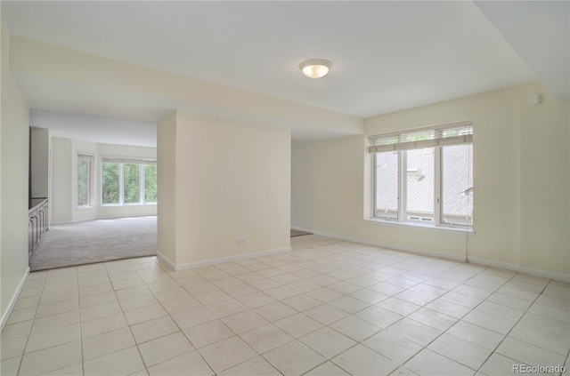 spare room with light tile patterned flooring and baseboards