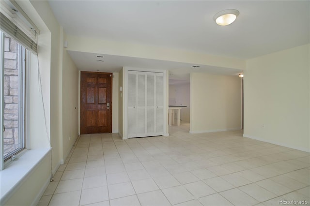 unfurnished room featuring light tile patterned floors and baseboards