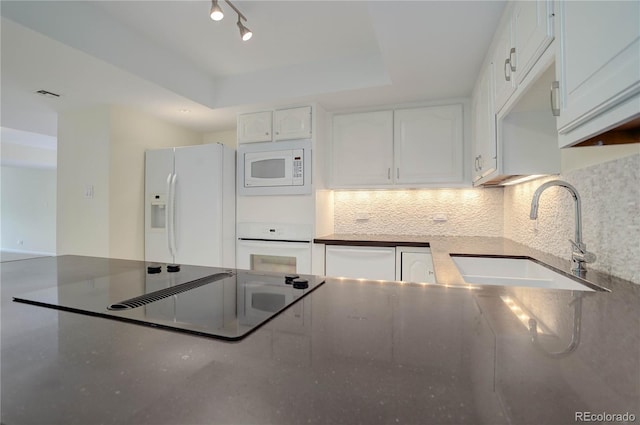 kitchen featuring white cabinets, white appliances, decorative backsplash, and a sink