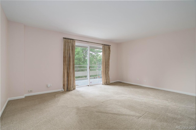 carpeted spare room featuring baseboards