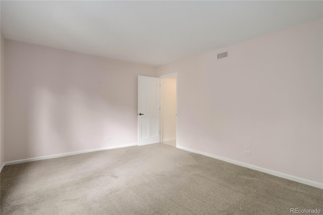 empty room with carpet floors, baseboards, and visible vents