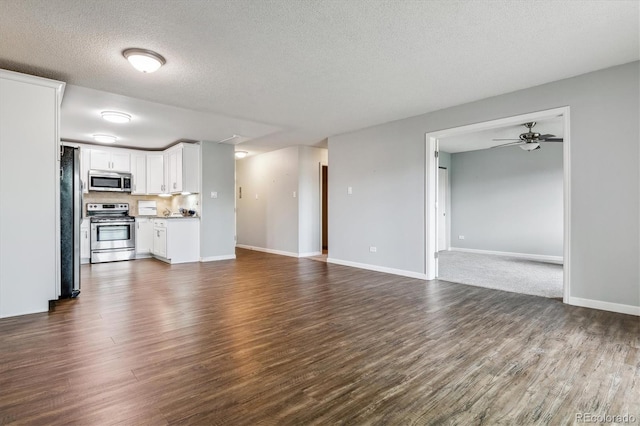 unfurnished living room with ceiling fan, dark hardwood / wood-style floors, and a textured ceiling